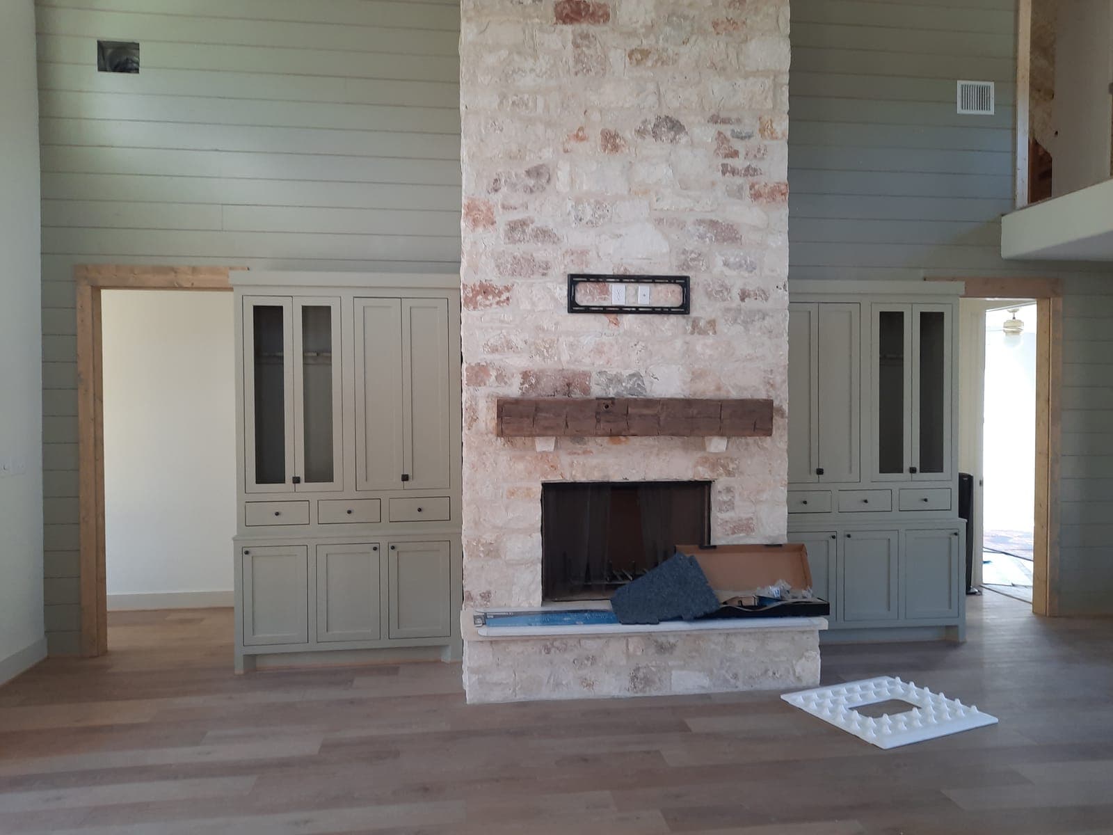 Floor-to-ceiling stone fireplace with custom cabinets