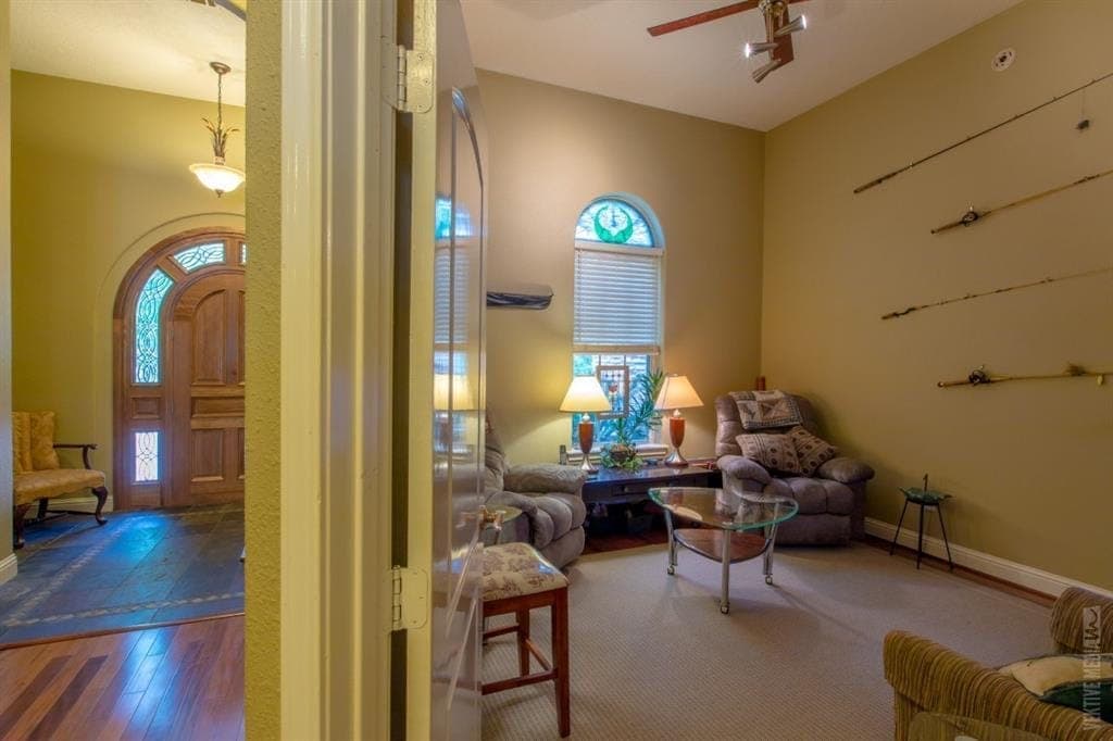 Living area with arched wood front door beyond