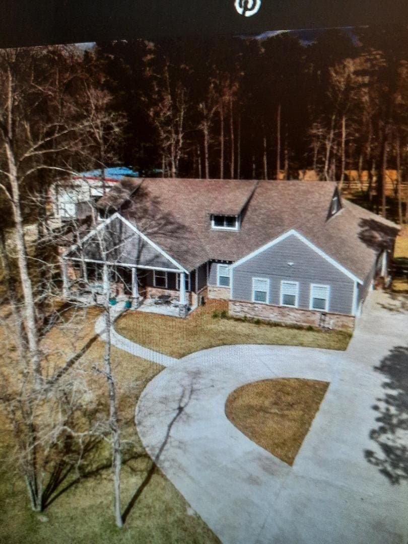 Aerial view of custom ranch home and driveway