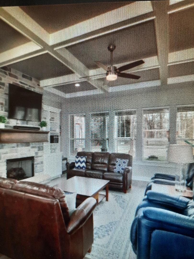 Living room with coffered ceiling and stone fireplace